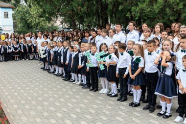 Okul çocukları toplantısı: Açık havada düzenlenen törene üniformalı bir grup genç öğrenci katılıyor. 2 Eylül 2024 Balti Moldova.