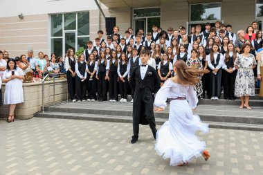 Genç Kafkas gençler okul etkinliğinde seyirciyle dans ediyorlar. 2 Eylül 2024 Balti Moldova.