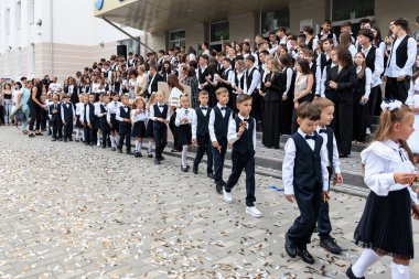 Okul etkinliği çocuklar ve yetişkinlerin resmi kıyafetleriyle. 2 Eylül 2024 Balti Moldova.