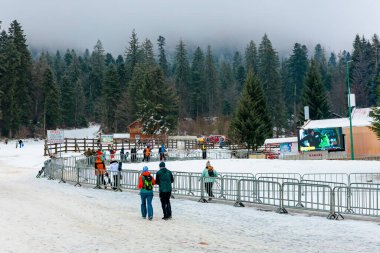 İnsanlar ve karlı manzaralı kış kayak merkezi sahnesi. 15 Aralık 2024 'te Romanya.