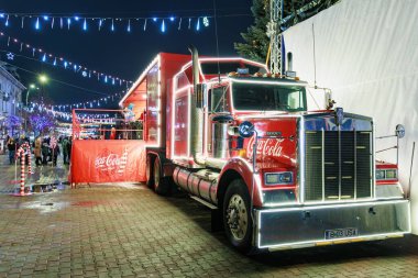 Geceleri Noel ışıkları ve süslemelerle şenlikli Coca-Cola kamyonu. 27 Aralık 2024 Balti Moldova.