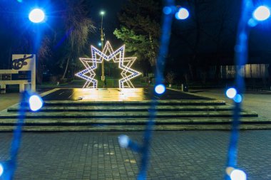 Yıldız şeklindeki ışık heykeli geceleri parkın yolunu aydınlatıyor. 27 Aralık 2024 Balti Moldova.