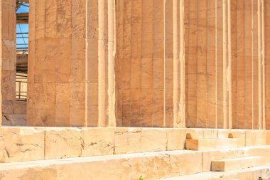 Bir sürü sütunu olan taş bir bina. Bina eski görünüyor ve çok fazla tarihi var. Sütunlar uzun ve boşluklu, Atina 'da Akropol