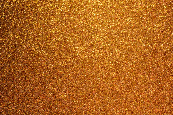 Bir sürü parıltısı olan altın bir arka plan. Parıltı yayılmış ve arka plan çok parlak.