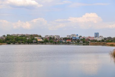 Sakin şehir manzarası bulutlu bir gökyüzünün altında dingin bir göl..