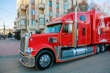 Yanında Coca Cola markası olan kırmızı bir kamyonet. Kamyon bir binanın önündeki tuğla bir yolda park halinde. 27 Aralık 2023 Balti Moldova