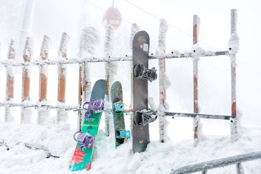 Kar kaplı snowboardlar ve kar çitleri kış harikalar diyarının ortasında. 15 Aralık 2024 'te Romanya.
