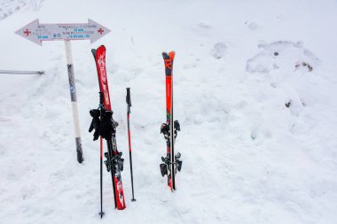 Karlı dağlarda parlak kırmızı kayaklar ve kutuplar. 15 Aralık 2024 'te Romanya.