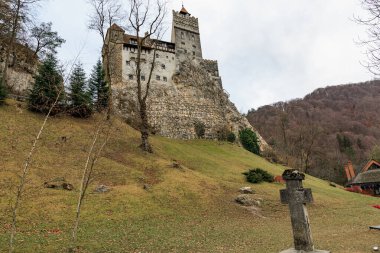 Castle yerde haç olan bir tepede. 16 Aralık 2024 Bran Romanya.