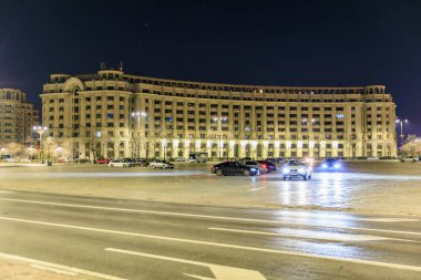 Aydınlatılmış Bükreş binasının ve otoparkın gece görüşü. 8 Mart 2025 Bükreş Romanya.
