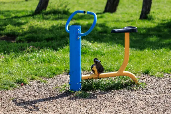 Güneşli bir günde yeşil alanda açık hava parkı egzersiz ekipmanları.