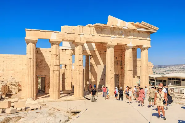 Bir grup insan sütunları olan bir binada yürüyorlar. Bina eski ve bir sürü tarihi var. 9 Ağustos 2024 Atina Yunanistan