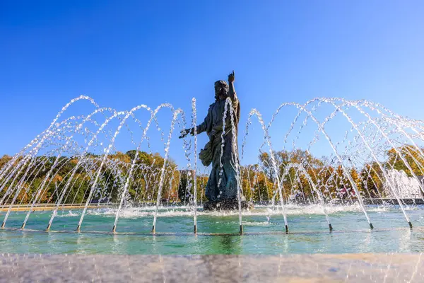 Ortasında bir adam heykeli olan bir çeşme. Su fıskiyeden dairesel bir şekilde fışkırıyor. Gökyüzü açık ve mavi. 27 Ekim 2024 Chisinau Moldova
