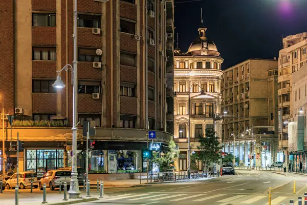 Gece vakti, tarihi bina ve mimarisi aydınlatılmış şehir caddesi. 8 Mart 2025 Bükreş Romanya.