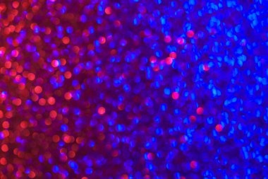 Mavi ve kırmızı noktalı renkli bir arka plan. Arka plan iki rengin karışımı, canlı ve enerjik bir atmosfer yaratıyor. Noktalar arka plana saçılmış.