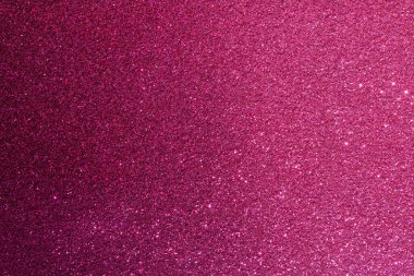 Pembe bir arka plan ve bir sürü parıltı. Parıltı farklı boyutlarda ve her yere saçılmış.