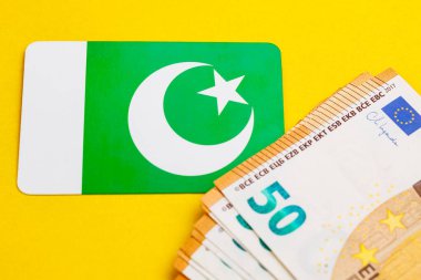 Sarı arka planda avro banknotları olan Pakistan bayrağı.