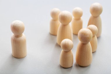 Sosyal dışlanmayı ve grup dinamiği kavramını tasvir eden ahşap figürler.