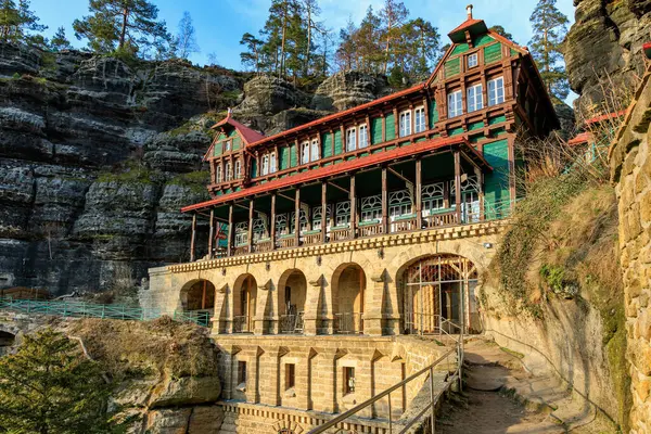 Tarihsel dağ kulübesi kumtaşı kaya oluşumlarına yuva yapmış yeşil çam ormanlarıyla.