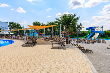 Havuzu ve bir sürü şezlongu olan bir plaj. Sandalyeler yayılmış ve bazıları şemsiyelerin altında. 8 Haziran 2024 Balti Moldova