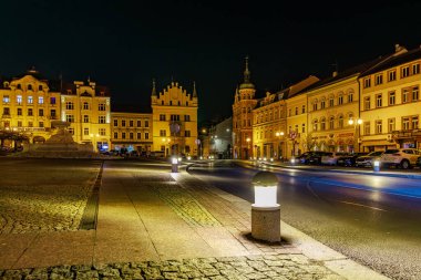 Geceleyin aydınlatılmış binalar ve sokak lambalarıyla tarihi Avrupa şehir meydanı. 16 Mart 2025, Decin, Çek Cumhuriyeti.