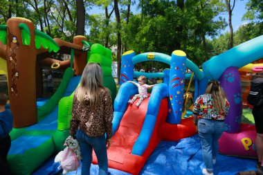 Çocuklar dışarıda renkli şişme oyun alanının tadını çıkarıyorlar. 31 Mayıs 2024 Balti Moldova.