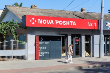 Parsel kilitli Nova Posta Ofisi ve güneşli bir günde kadın yaya. 9 Eylül 2024 Balti Moldova.