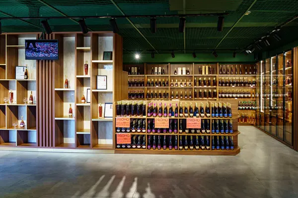 Ahşap raflar ve çeşitli şişeler sergilenen modern içki dükkanı. 1 Mart 2023 Balti Moldova.