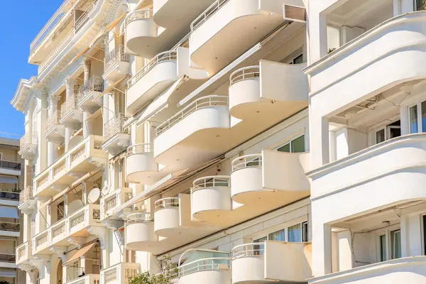 Balkonları ve tenteleri olan yüksek bir bina. Bina beyaz ve bir sürü penceresi var. 8 Ağustos 2024 Selanik Yunanistan