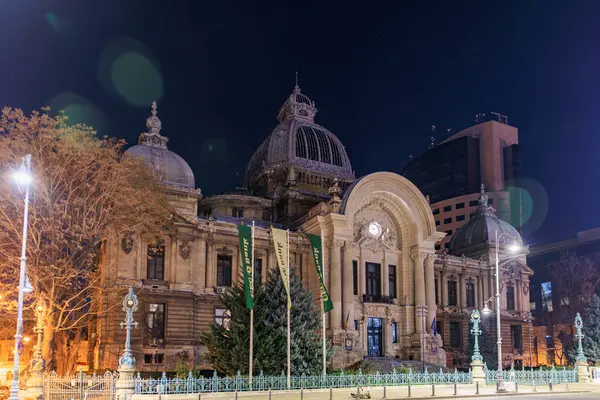 Bükreş 'teki tarihi Cec Palace' ın aydınlatılmış mimarisiyle gece görüşü. 8 Mart 2025 Bükreş Romanya.