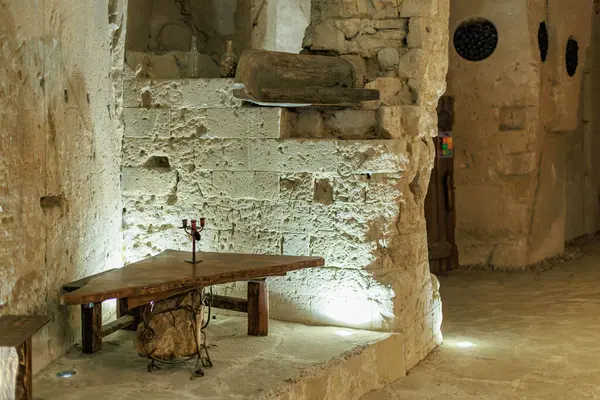 Ahşap masa ve sıcak ışıklandırmalı antik taş döşeme. 6 Nisan 2025 Branesti, Moldova.