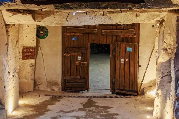 Kırsal ahşap çift kapılı antik taş bina içi sıcak ışıklandırmalı. 6 Nisan 2025 Branesti, Moldova.