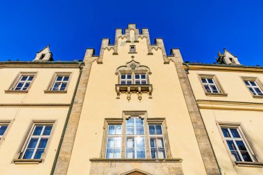 Açık mavi gökyüzü ile parlak güneş ışığında tarihi Avrupa kalesi cephesi.