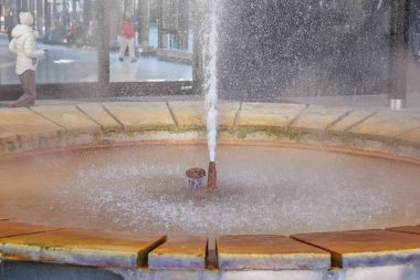 Şehir ortamında dikey akışına sahip dairesel su çeşmesi, doğal gayzer..