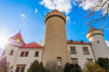 Mavi gökyüzünün altında kırmızı çatıları olan görkemli ortaçağ kalesi.