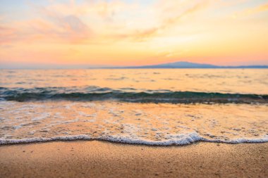 Okyanus sakin ve gökyüzü güzel turuncu bir renktir. Su açık mavi bir renktir.