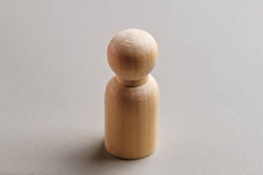 Tarafsız arkaplanda basit tahta bebek heykeli.