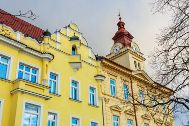 Sarı cephe ve saat kulesine sahip tarihi Avrupa mimarisi.