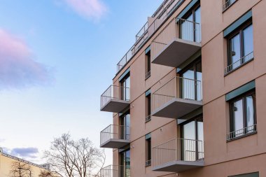 Gökyüzüne karşı balkonları olan modern bir apartman..