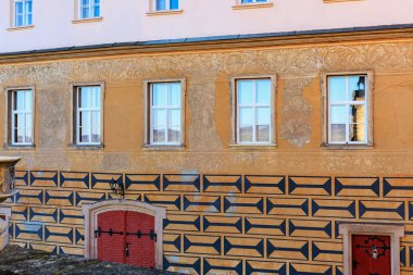 Geometrik desenler ve dekoratif sıva ile tarihi yapı cephesi.