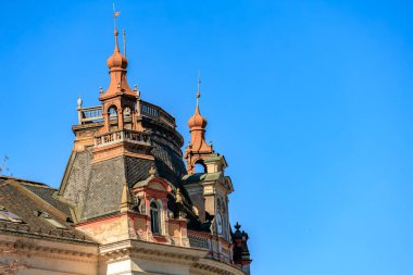 Temiz mavi gökyüzüne karşı tarihi Avrupa binasının süslü çatısı.