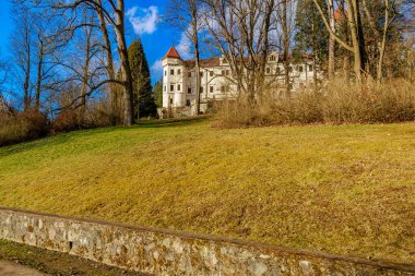 Açık mavi gökyüzünün altında kulesi olan tarihi bir konak..