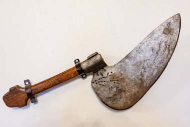 Beyaz duvarda tahta saplı ve metal bıçaklı antika et satırı..