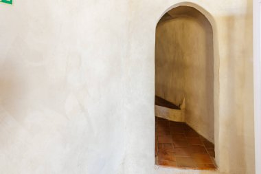 Kemerli girişi ve terra cotta zemini olan tarihi dar taş koridor..