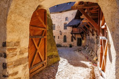 Ortaçağ şatosunun avlusunda ahşap kapılar ve taş yollar var..