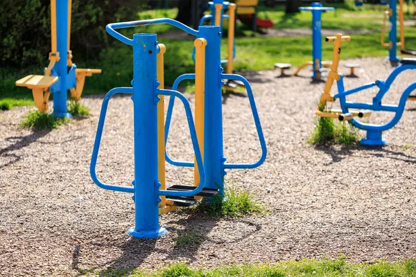 Güneşli bir günde halka açık parkta spor aletleri.