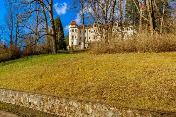 Açık mavi gökyüzünün altında kulesi olan tarihi bir konak..