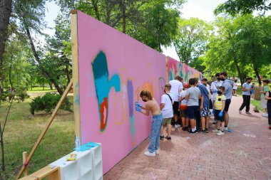 Genç sanatçılar park ortamında renkli grafiti resimleri yapıyorlar. 31 Mayıs 2024 Balti Moldova.