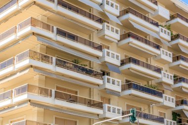 Balkonları ve tenteleri olan yüksek bir bina. Balkonlar boş. Bina beyaz. 8 Ağustos 2024 Selanik Yunanistan