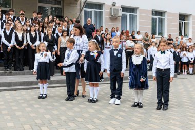 Okul seremonisinde öğretmenleri ve aileleri olan çocuklar. 2 Eylül 2024 Balti Moldova.